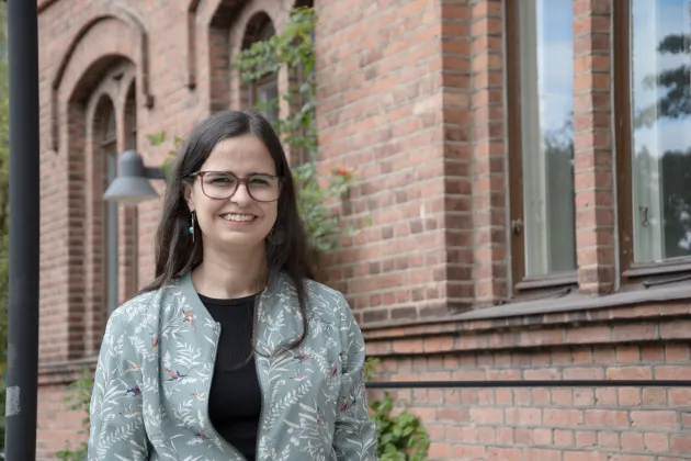 Lucia Amaranta Thompson utanför tegelbyggnaden Pufendorfinstitutet där disputationen ägde rum. Foto: Emma Lord.